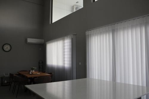 a white kitchen with a table and a window at Ocean Bliss Penthouse - Private Pool & 2 Min to Beach in Flic-en-Flac