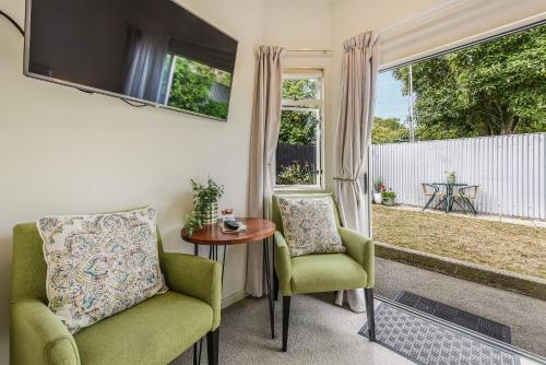 a living room with two chairs and a table and a window at Boutique Motel in Nelson