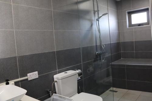 a bathroom with a shower and a toilet and a sink at Ocean Bliss Penthouse - Private Pool & 2 Min to Beach in Flic-en-Flac