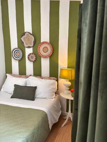 a bedroom with a bed with green and white stripes at No Meio da Natureza - Turismo No Espaco Rural in Vila Nova de Famalicão