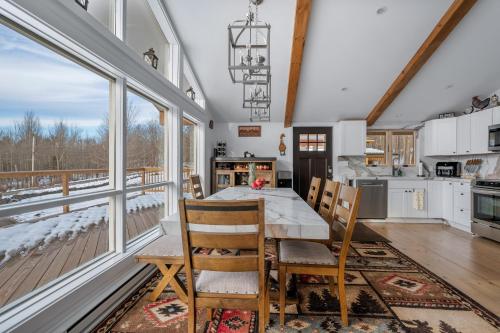 a kitchen with a table and chairs and windows at Catskills Mountain Retreat - Luxury Meets Serenity in Jewett