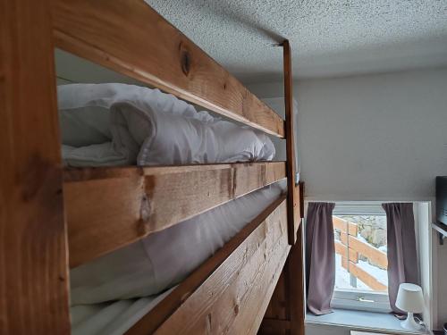 Ce lit superposé en bois se trouve dans un dortoir doté d'une fenêtre. dans l'établissement Studio Cosy pour 4 personnes en RDC, à Villard-de-Lans