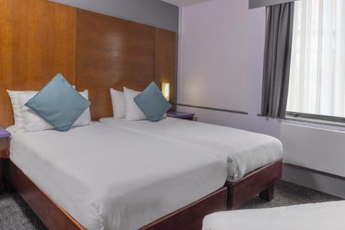 a bedroom with a large white bed with blue pillows at Best Western Sheffield City Hotel in Sheffield