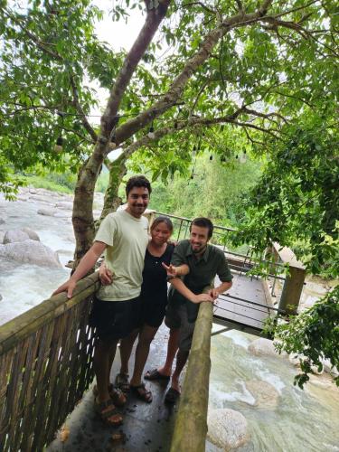 a group of three people standing on a wooden bridge at Dong Que Homestay-Tours-Motorbike, Car rental, Hiking in Ha Giang