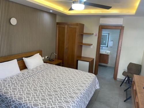 a hotel room with a bed and a bathroom at New Garden Hotel in Sosúa