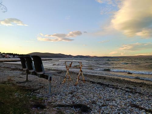 two chairs and a table on the beach at Apartmani Dino in Bilice