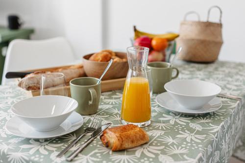 a table with two plates and a glass of orange juice at La Plage, T2 vue mer in Rivedoux-Plage