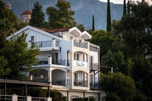 a white building with balconies on a mountain at Boka Bay Residences in Herceg-Novi