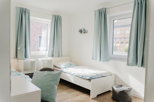 une chambre avec deux lits et une fenêtre dans l'établissement Ferienhaus Dorfkiek - Bauernhof Hopp Vadersdorf, à Fehmarn