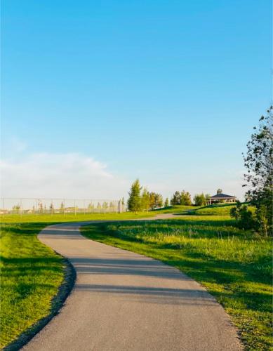 a winding road in the middle of a field at Luxury Modern 2-Bedroom Suite in Airdrie