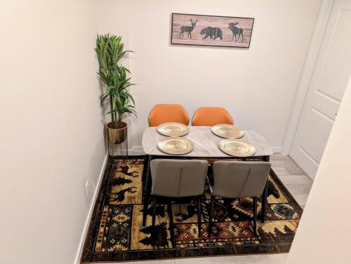 a dining room with a table and chairs on a rug at Luxury Modern 2-Bedroom Suite in Airdrie