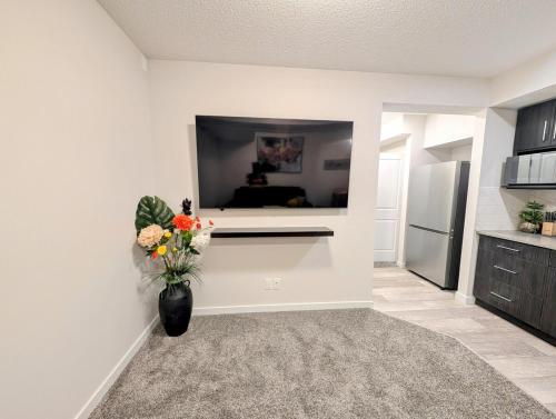 a kitchen with a vase of flowers on the wall at Luxury Modern 2-Bedroom Suite in Airdrie