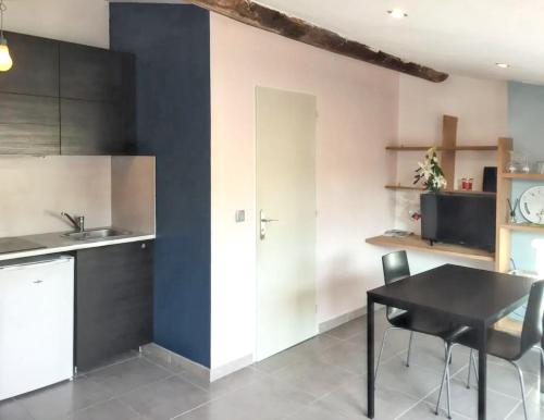une cuisine avec une table noire et une chaise noire dans l'établissement Studio moderne à Aix-en-Provence - 20 m² avec terrasse !, à Aix-en-Provence