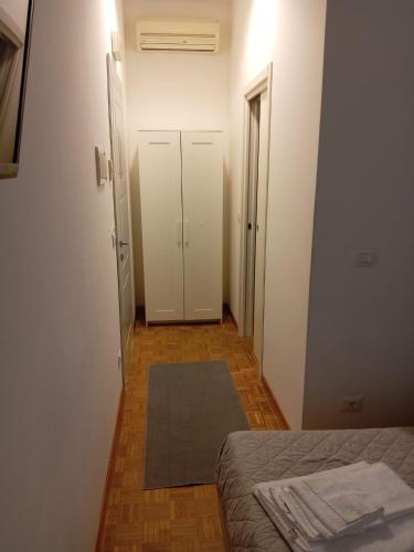 a room with a bed and a hallway with two doors at Affittacamere Iris in Trieste