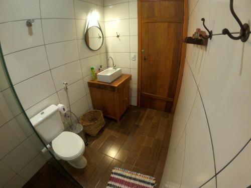 a small bathroom with a toilet and a sink at Chalé Biribó in Conceição do Mato Dentro