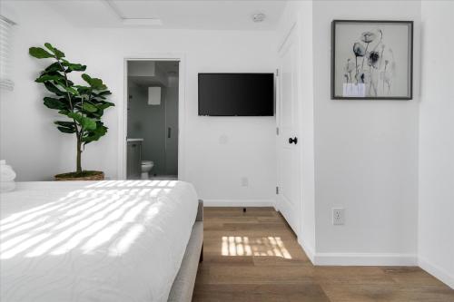 a white bedroom with a bed and a tv at Old Town Stunner in Cottonwood