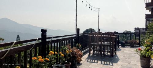 a balcony with a table and chairs and flowers at Bandipur Good Hotel Inn in Bandīpur