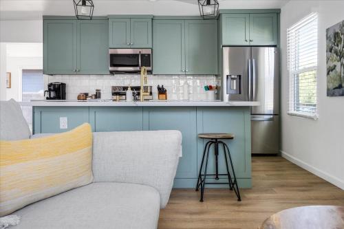 a kitchen with green cabinets and a gray couch at Old Town Stunner in Cottonwood