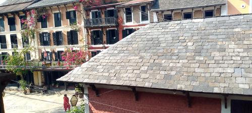 a building with a gray roof and some buildings at Bandipur Good Hotel Inn in Bandīpur