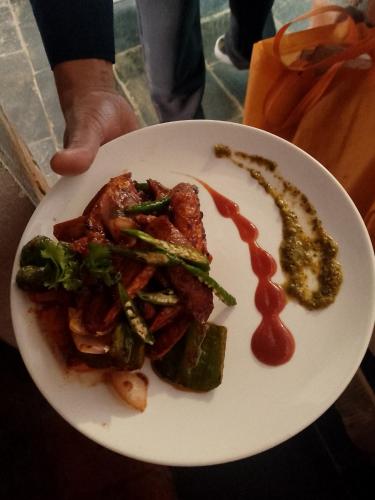 a plate of food with meat and vegetables and sauce at Bandipur Good Hotel Inn in Bandīpur