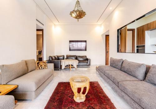 a living room with couches and a table at prestigieuse à casa finance city in Casablanca