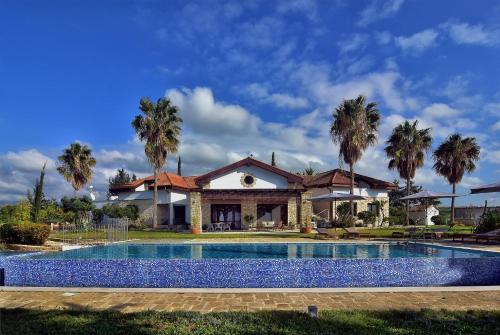 a house with a swimming pool in front of a house at Villa Margarita in Polis Chrysochous