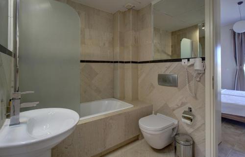 a bathroom with a tub and a toilet and a sink at Constantin in Dhémbla