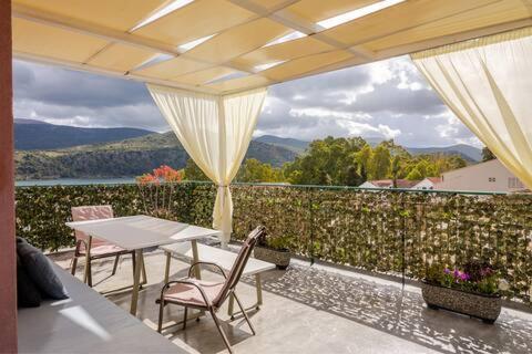 a patio with a table and chairs on a balcony at Argostoli Terrace Loft with Sea Views in Argostoli