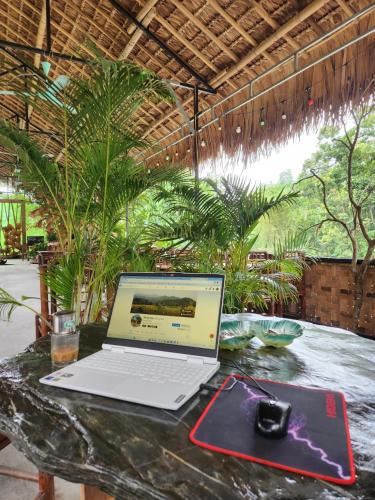 a laptop computer sitting on a table with a mouse at Dong Que Homestay-Tours-Motorbike, Car rental, Hiking in Ha Giang