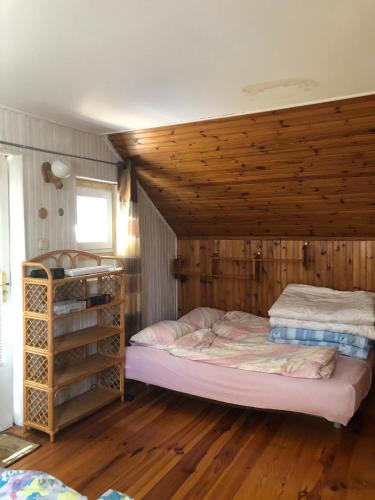 a bedroom with a bed and a wooden ceiling at Domek Spokojna Przystań in Przybrodzin