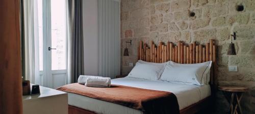 a bedroom with a bed with a brick wall at PALAZZO CAVÌ in Mola di Bari