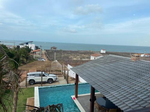 a car parked next to a house with a swimming pool at Home Beach at a Small Village in Cajueiro da Praia - Piauí - Brazil in Cajueiro