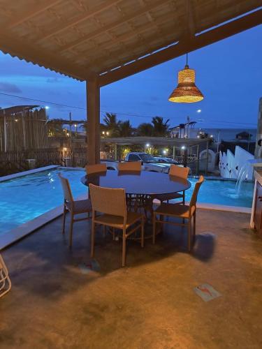 a table and chairs on a patio with a pool at Home Beach at a Small Village in Cajueiro da Praia - Piauí - Brazil in Cajueiro
