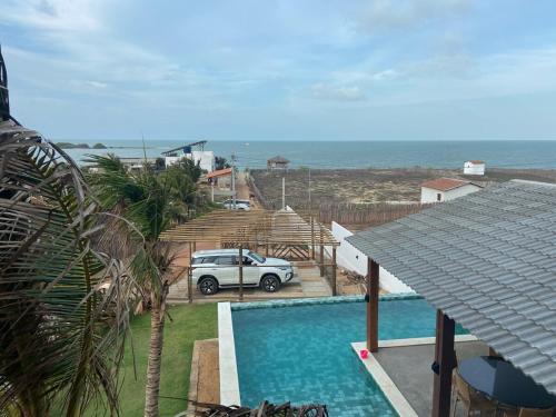 a car parked next to a swimming pool next to the ocean at Home Beach at a Small Village in Cajueiro da Praia - Piauí - Brazil in Cajueiro