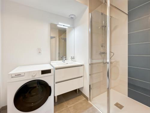 une machine à laver dans une salle de bain avec douche dans l'établissement L'échappée Belle Terrasse et Plages Saint Coulomb, à Saint-Coulomb