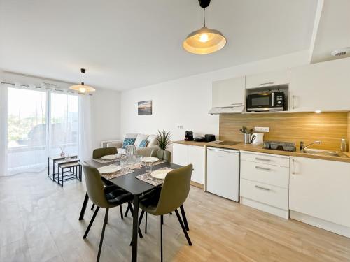 une cuisine et une salle à manger avec une table et des chaises dans l'établissement L'échappée Belle Terrasse et Plages Saint Coulomb, à Saint-Coulomb