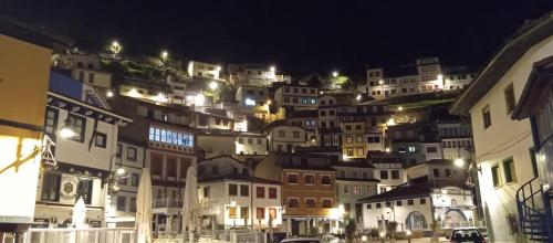a bunch of buildings on a hill at night at Galateastur in Cudillero