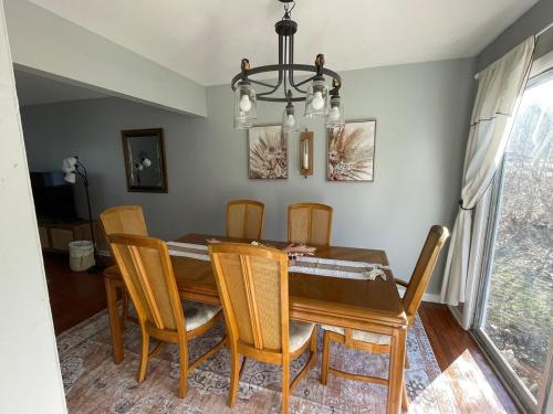 a dining room table with chairs and a chandelier at Sand Run Metro Park Getaway Home in Akron
