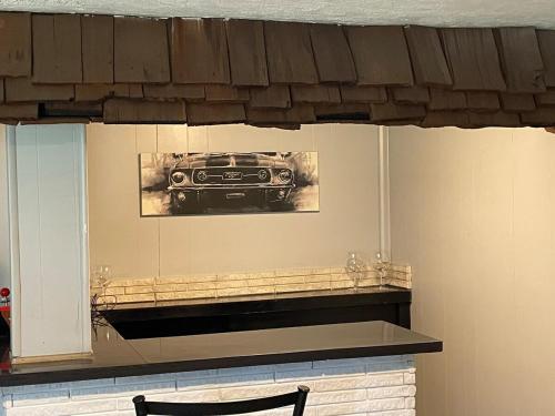 a picture of a car hanging above a fireplace at Sand Run Metro Park Getaway Home in Akron