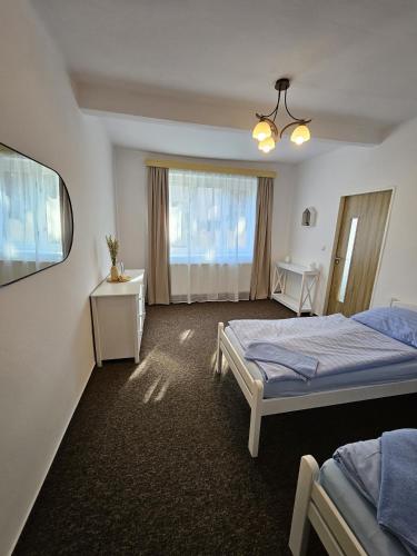 a hotel room with two beds and a window at Rodinný apartmán U Kuby in Chlumec nad Cidlinou