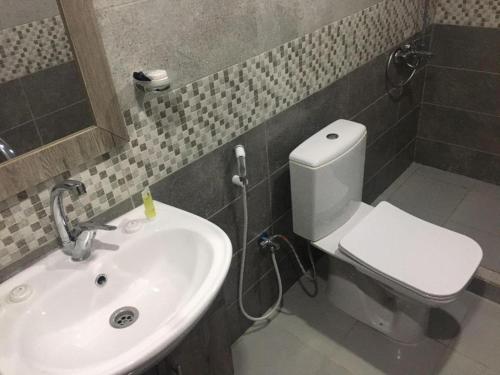 une salle de bain avec des toilettes blanches et un lavabo dans l'établissement Faiesal Luxury camp & Tour, à Wadi Rum