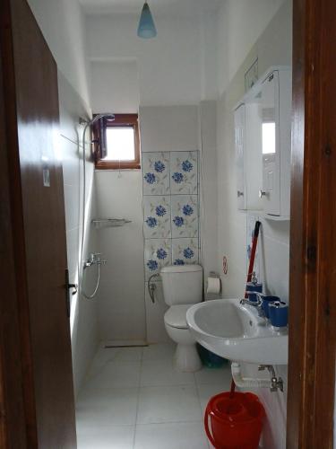 a white bathroom with a toilet and a sink at Sunny House in Pyrgadikia