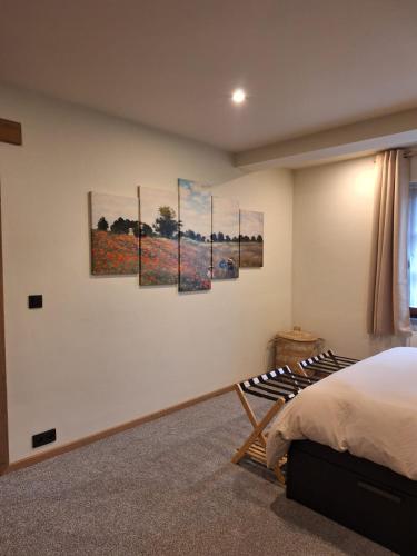 a bedroom with four paintings on the wall at Le Gite des Croisettes in Les Croisettes