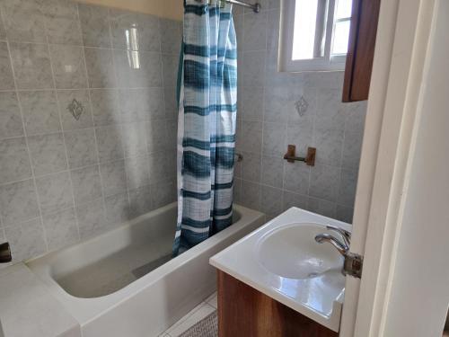 a bathroom with a sink and a bath tub at Poinciana House in Montego Bay
