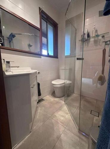 a bathroom with a toilet and a glass shower at Cherry Haven farm house with a view in Wandin East