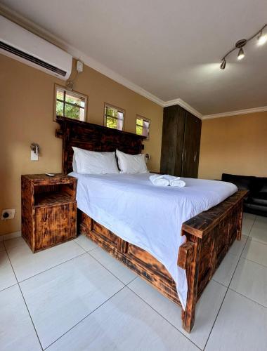 a bedroom with a large bed with a wooden frame at Dithabeng View Guest House in Rustenburg