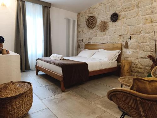a bedroom with a bed and a stone wall at PALAZZO CAVÌ in Mola di Bari