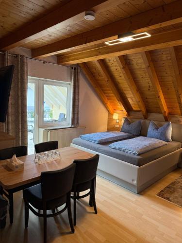 a bedroom with a bed and a table with chairs at Gästehaus Rana in Rust
