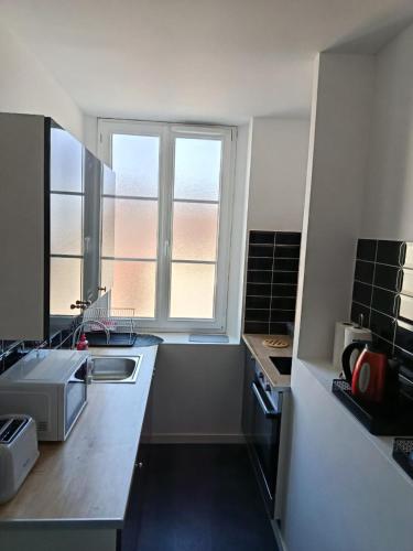 une cuisine avec un évier et une fenêtre dans l'établissement maison luxe orion aeroport tillé 2 a 4 personnes, à Tillé