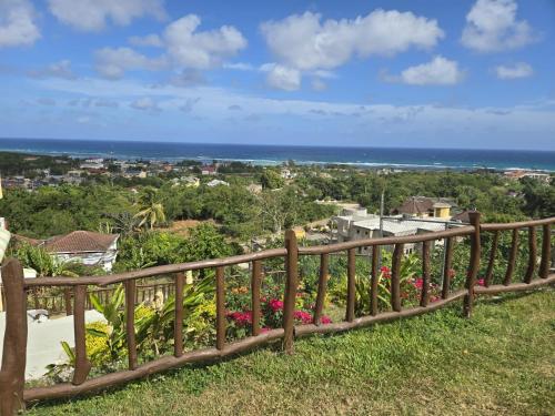 a wooden fence with a view of the ocean at Poinciana House in Montego Bay